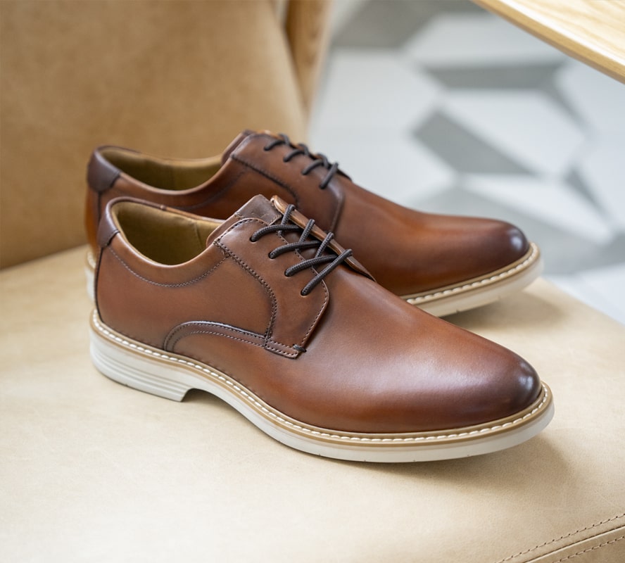 Shop Florsheim top sellers featuring the Norwalk plain toe oxford in cognac on a leather chair. 
