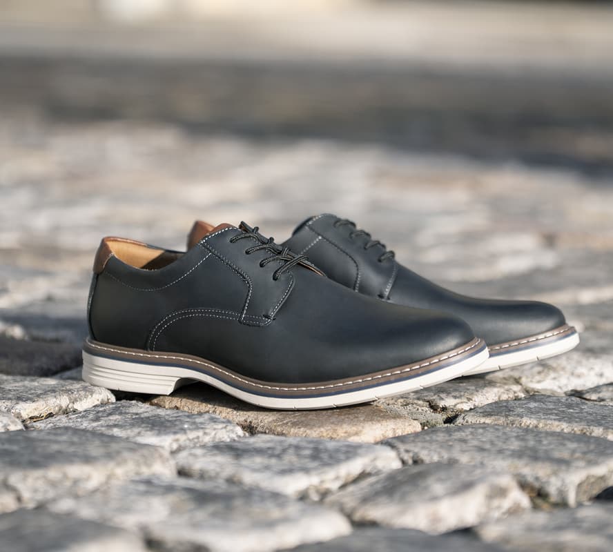 Shop the Florsheim Hybrid category featuring the Norwalk Plain Toe Oxford in Black on a stone background.