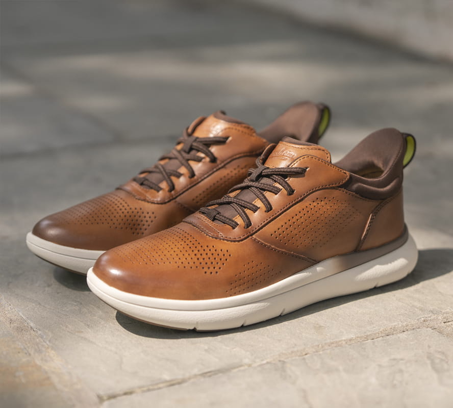Shop Florsheim hybrids featuring the Fleet perf sneaker in cognac on a concrete surface.