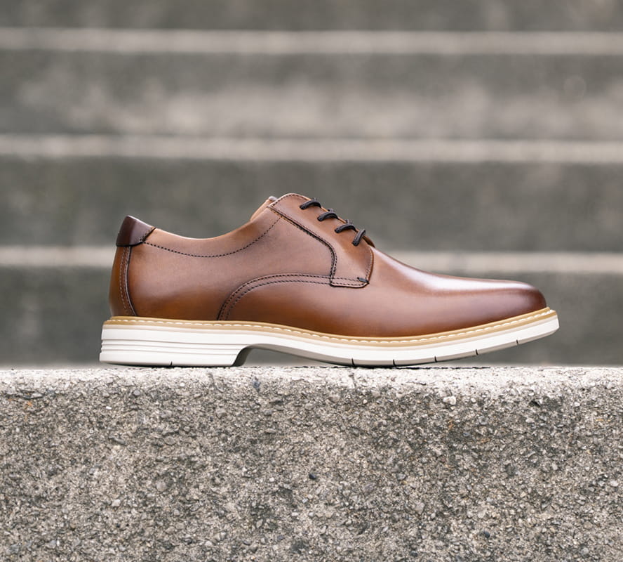 Shop Florsheim hybrids featuring the Norwalk plain toe oxford in cognac on a concrete step.
