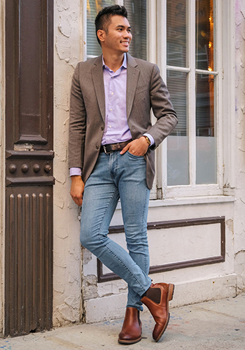 Image of social media influencer Justin Borbe leaning up against a window wearing the Lodge Plain Toe Boot in Chestnut.