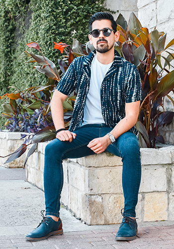 Image of social media influencer Cristobal Benavides sitting outside wearing the Highland II Plain Toe Oxford in Navy.