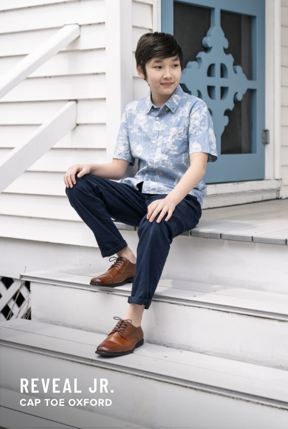 Boy's Dress Shoes category. Image features the Reveal Jr. in cognac.