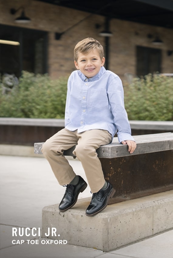 Boy's Dress Shoes category. Image features the Rucci Jr Cap Toe Oxford in black.