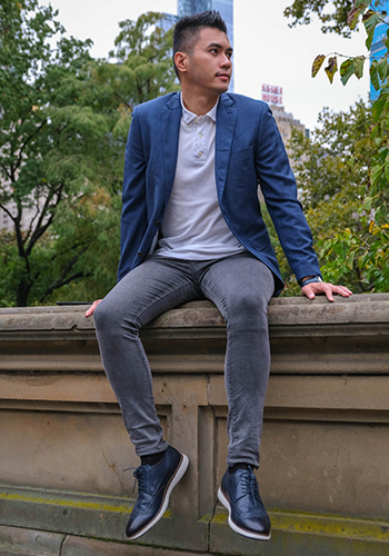 Image of social media influencer Justin Borbe sitting outside in Central Park wearing the Flair Wingtip Oxford in Navy.