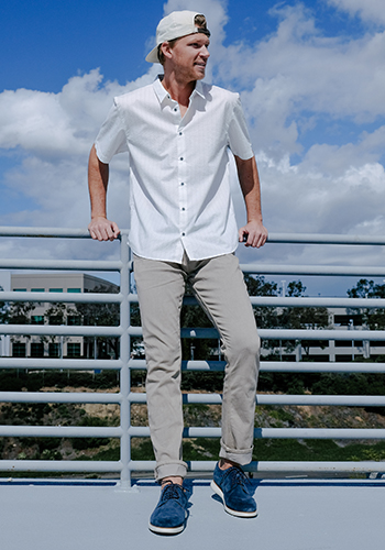 Image of social media influencer Drew Mellon wearing the Fuel 5-Eye Plain Toe Oxford in Navy Suede while standing against a railing in Newport Beach, California.