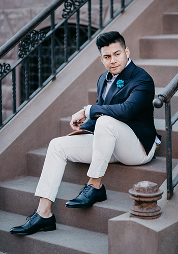 Image of social media influencer Diego Leon wearing the Amelio Cap Toe Oxford in Navy while sitting on the steps.