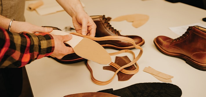 The featured image shows people working with shoe materials.