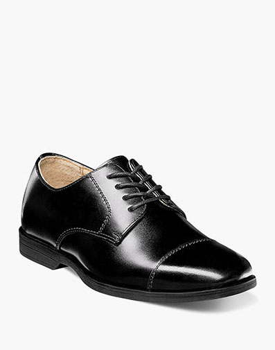 The featured product is the Reveal Jr. Cap Toe Oxford in Black Patent.